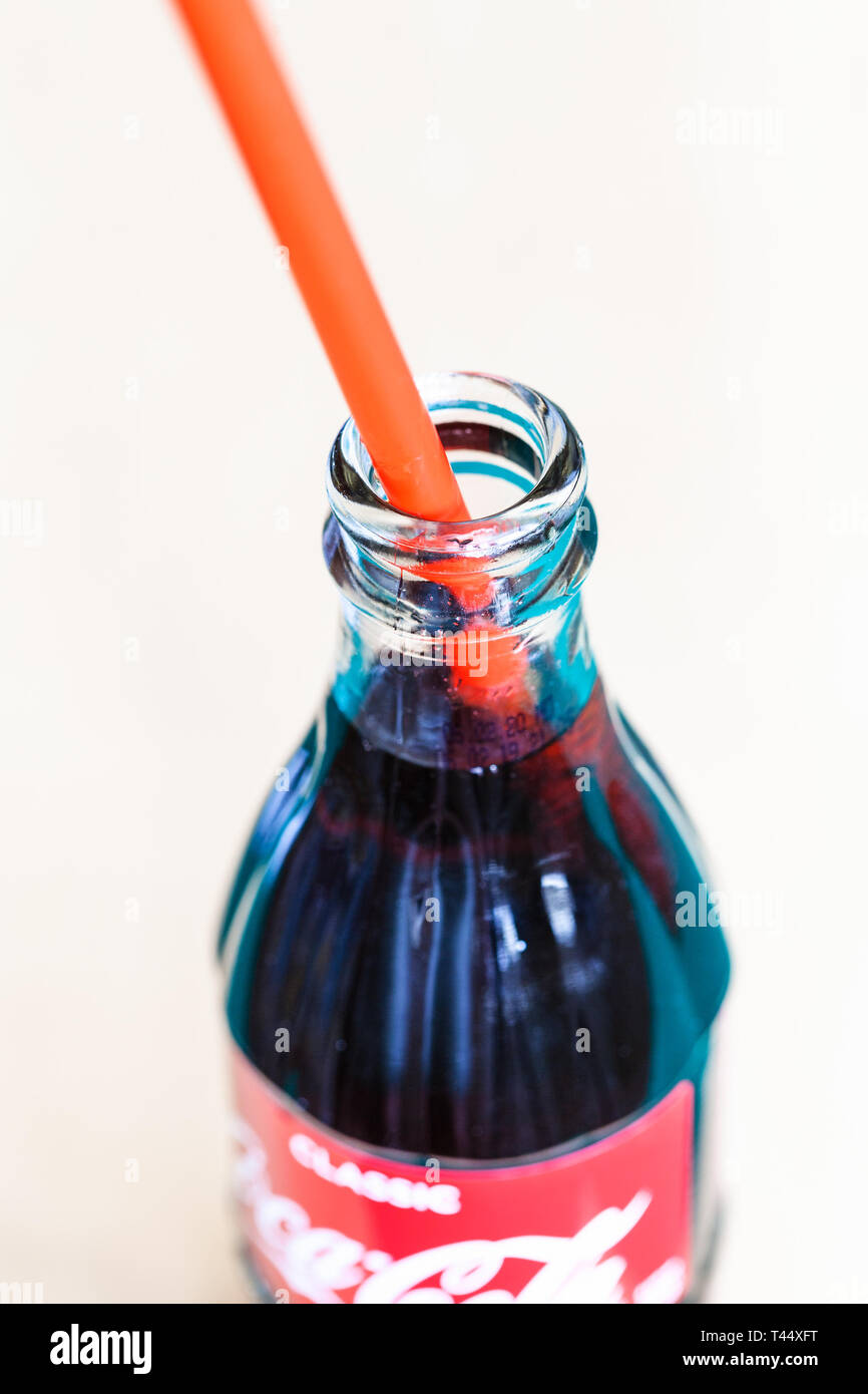Moscou, Russie - le 4 avril 2019 : ouvrir la bouteille en verre de Coca-Cola boisson avec paille rouge . Coca-Cola (coke) est la fabrication de boissons gazeuses Banque D'Images