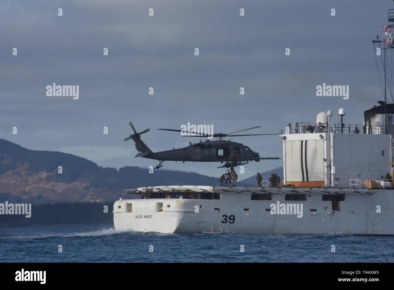 Plusieurs membres de la Sécurité maritime de la Garde côtière à l'ouest de l'équipe d'intervention monter une échelle dans une 176e Escadre, 210e Escadron de sauvetage en Alaska Air National Guard HH-60 hélicoptère Pavehawk depuis la cabine de pilotage de Les garde-côte de Alex Haley (WMEC 39) dans le cadre d'un exercice à Chiniak Bay, Alaska, le 23 février 2019. Les membres de l'équipe sont formés et techniquement compétents dans les techniques de pointe avec les gouvernements fédéral, des états et des partenaires locaux pour protéger le pays contre les menaces à la fois maritime et aérien. La Garde côtière américaine Banque D'Images