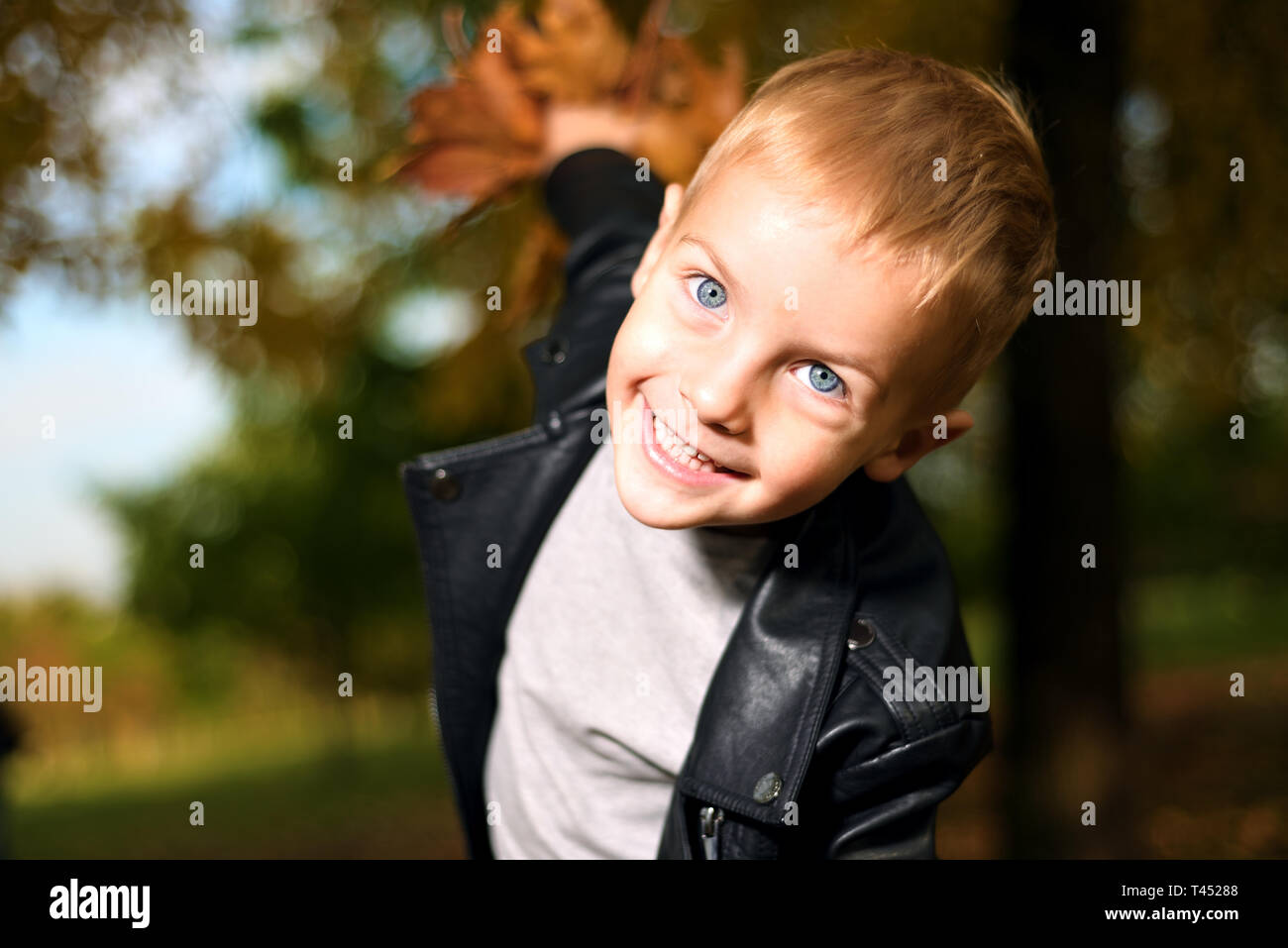Funny portrait of little boy sly en veste en cuir noire saison d'automne. Banque D'Images