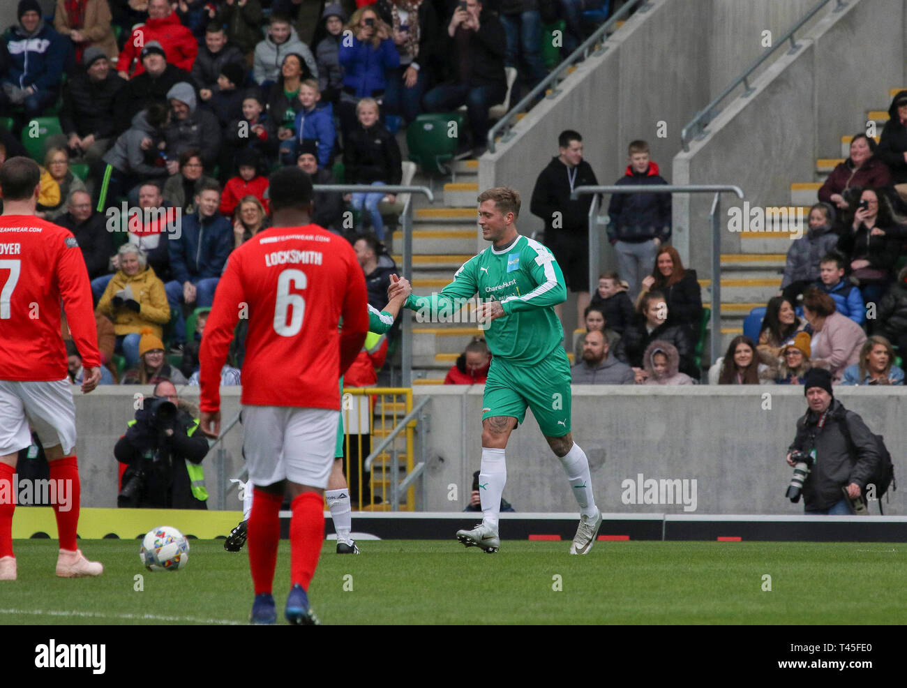 Windsor Park, Belfast, Irlande du Nord, Royaume-Uni. 14 avr, 2019. 'Ma' - Hommage à une célébrité match de football organisé par le Soccer Sellebrity avec Calum Best (fils de George Best, Manchester United l'Irlande du Nord et la légende) L'un des moteurs, avec d'autres, derrière elle. L'événement permettra d'amasser des fonds pour l'AOCNA (Association Nationale pour les enfants d'alcooliques) et l'Irish Sea Foundation. L'action de l'événement d'aujourd'hui. Dan Osborne (vert) célèbre son but. Crédit : David Hunter/Alamy Live News. Banque D'Images