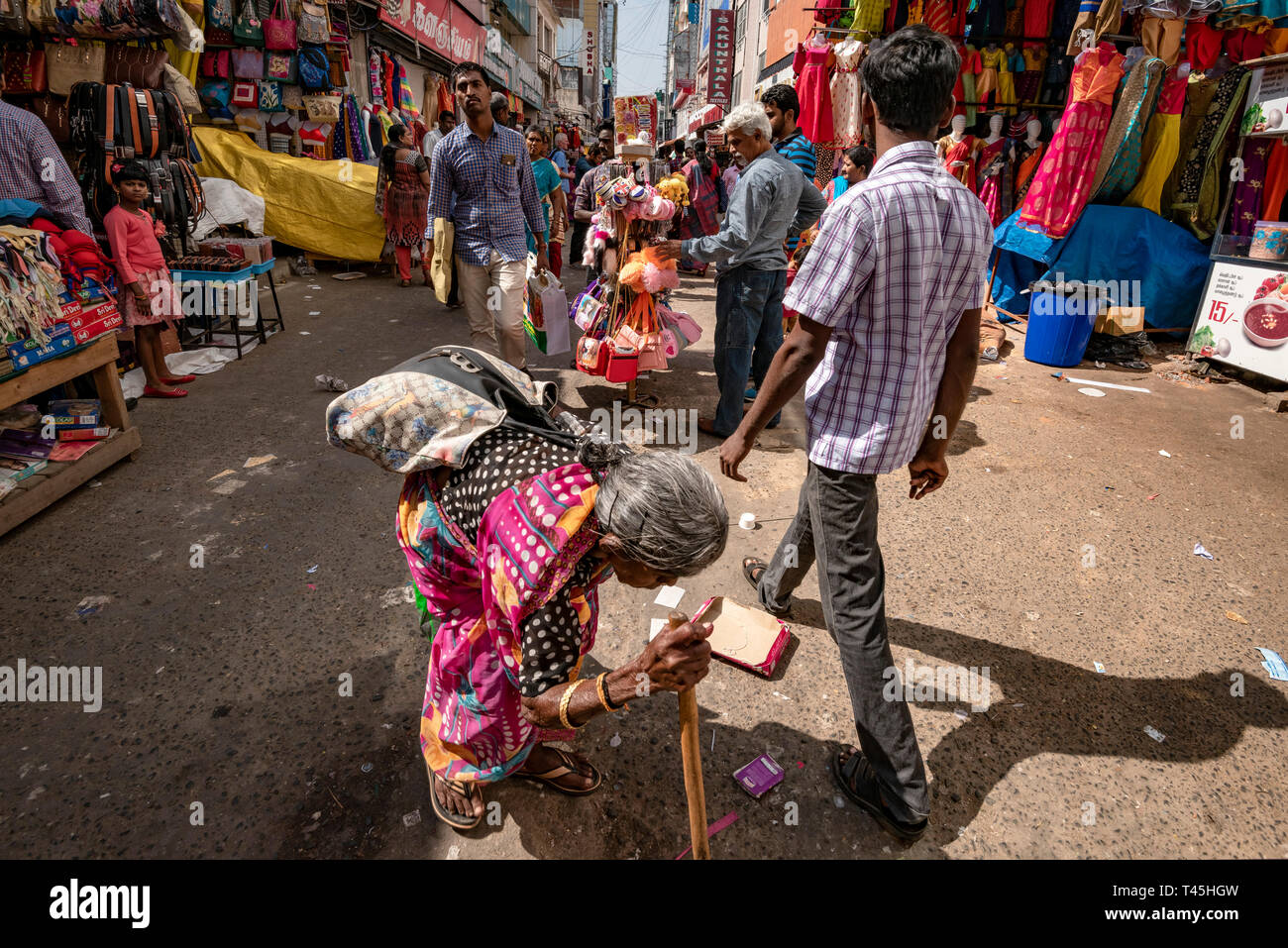Streetview horizontale d'une vieille dame mendier dans un quartier commerçant animé, en Inde. Banque D'Images