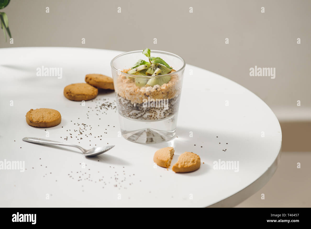 Prêt à manger sain un petit déjeuner nutritif - Granola aux amandes, graines de chia, banane et kiwi fruits et de baies et d'un bocal avec du lait à proximité Banque D'Images
