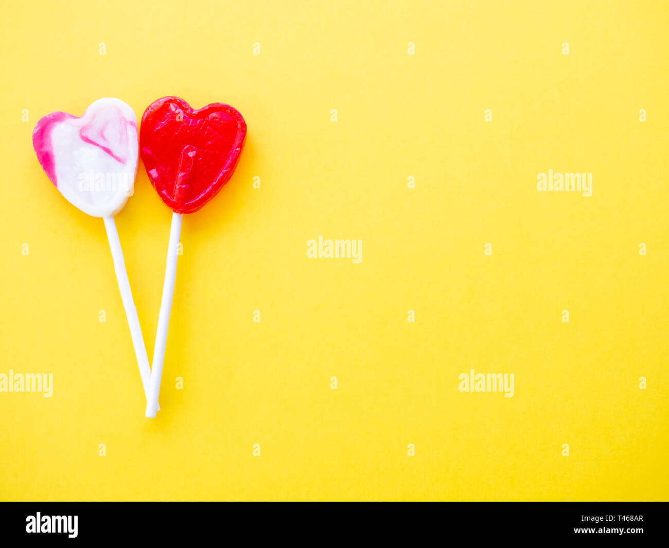 Sucette rouge et blanc et rose sur un fond jaune sucette Banque D'Images