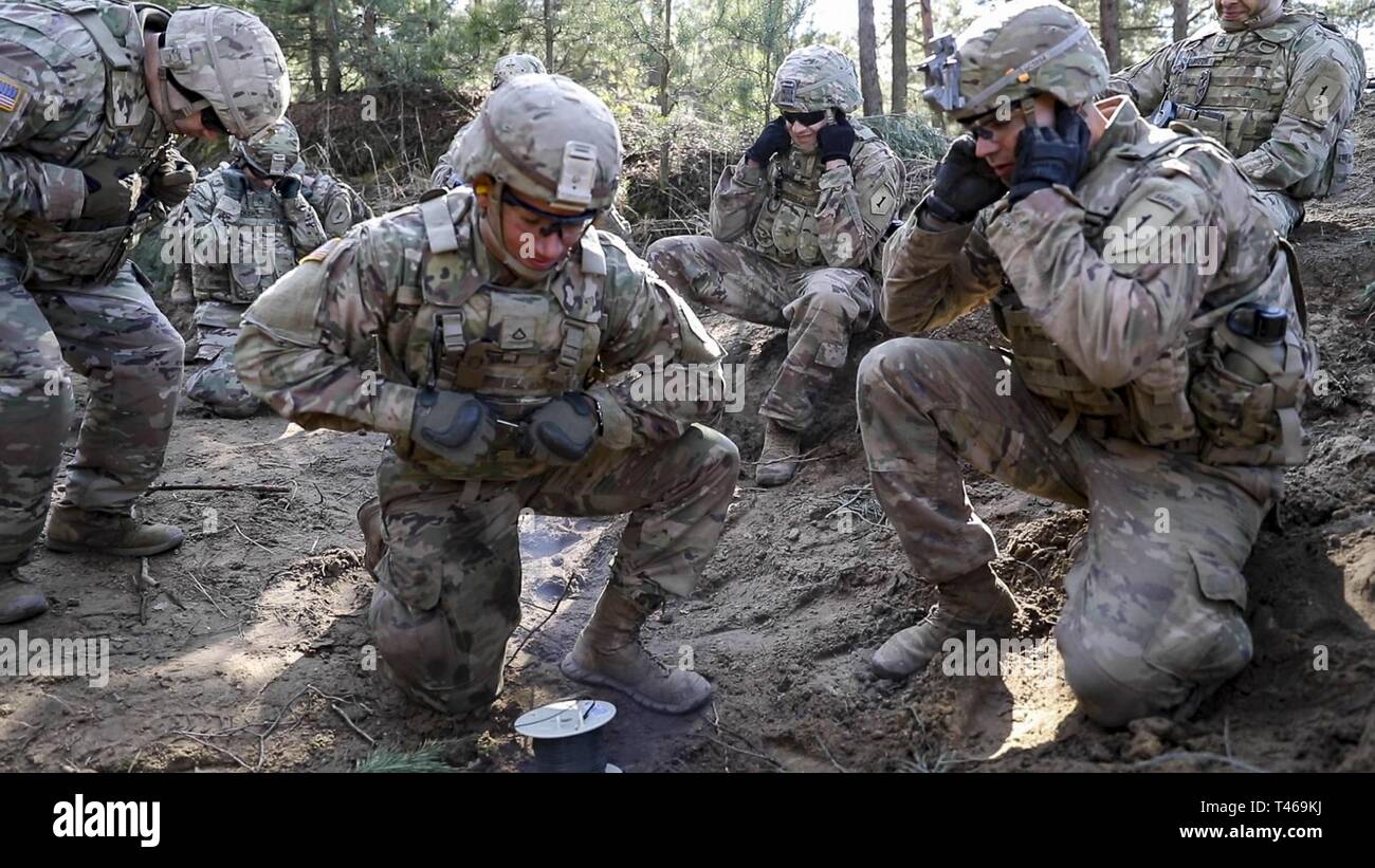 ZAGAN, Pologne -- Des soldats du 1er bataillon du génie, 1st Armored Brigade Combat Team, 1re Division d'infanterie, se mettre à couvert sous la forme d'un. Terry Isaac, ingénieur de combat avec le 1er. Bat., explose une explosion lors de la formation aux explosifs de tir réel à Joanna, ici, le 6 mars 2019. La Brigade du diable fait partie de plus de 6 000 soldats américains affectés à l'échelle régionale en Bulgarie, Estonie, Hongrie, Lettonie, Lituanie, Pologne et Roumanie, sur une rotation de neuf mois, à l'appui de la résolution de l'Atlantique. Banque D'Images