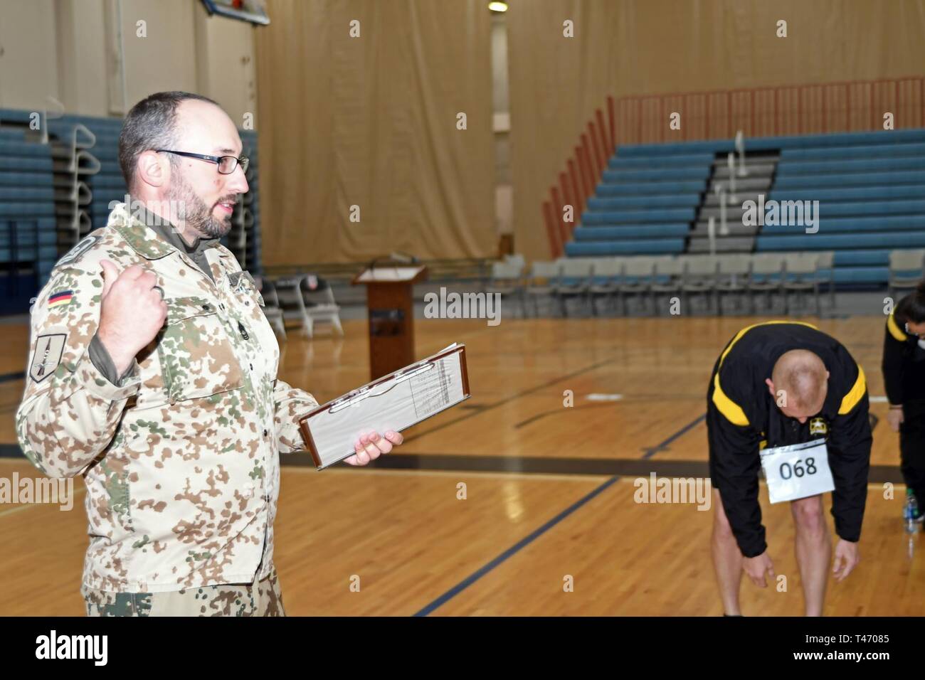 FORT BLISS, Texas - German Air Force Master Sgt. Roglmeier Frank, de la défense aérienne de l'Allemagne Centre, lit les conditions et les normes de la base allemande de l'armée américaine de Fitness Test soldats qui ont participé à l'armée allemande d'un insigne militaire pour leurs compétences en la Mitchell W. Stout Centre de remise en forme physique, de Fort Bliss, Texas, le 13 mars 2019. Banque D'Images