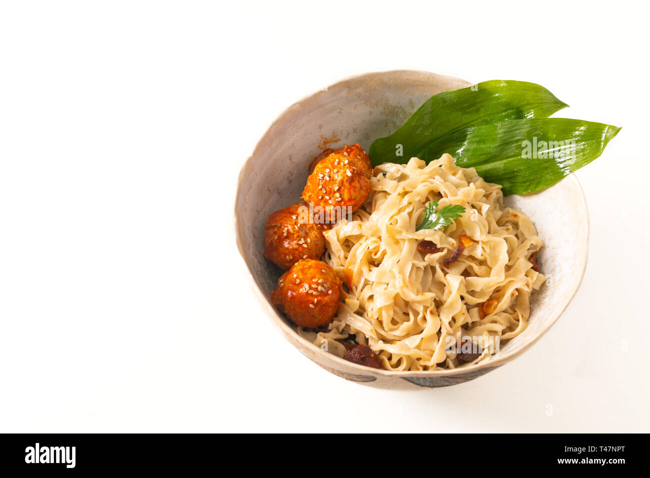 Concept alimentaire asiatique oriental des nouilles aux œufs et de boulettes épicées dans un bol en céramique sur fond blanc Banque D'Images