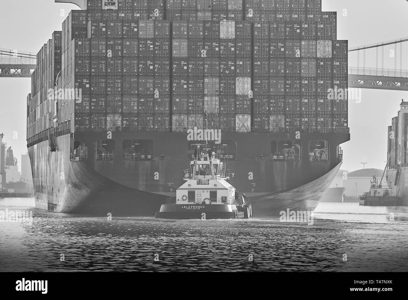 Photo en noir et blanc de la Stern View du porte-conteneurs, YM UNANIMITÉ, sous le pont Vincent Thomas au port de Los Angeles, en Californie Banque D'Images