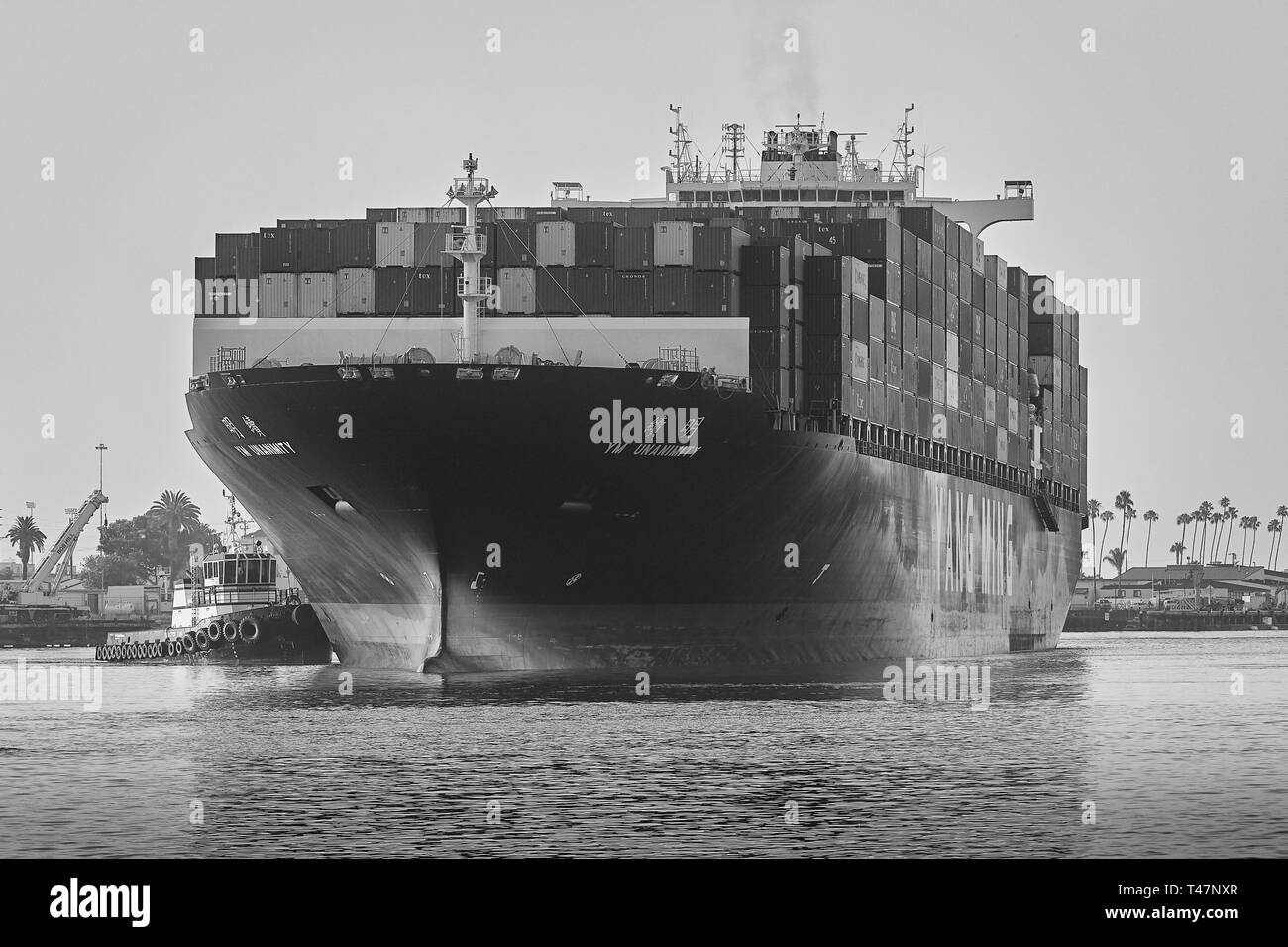 Photo en noir et blanc du porte-conteneurs, YM UNANIMITÉ, passant par le canal principal de Los Angeles, à destination du port de Los Angeles Banque D'Images