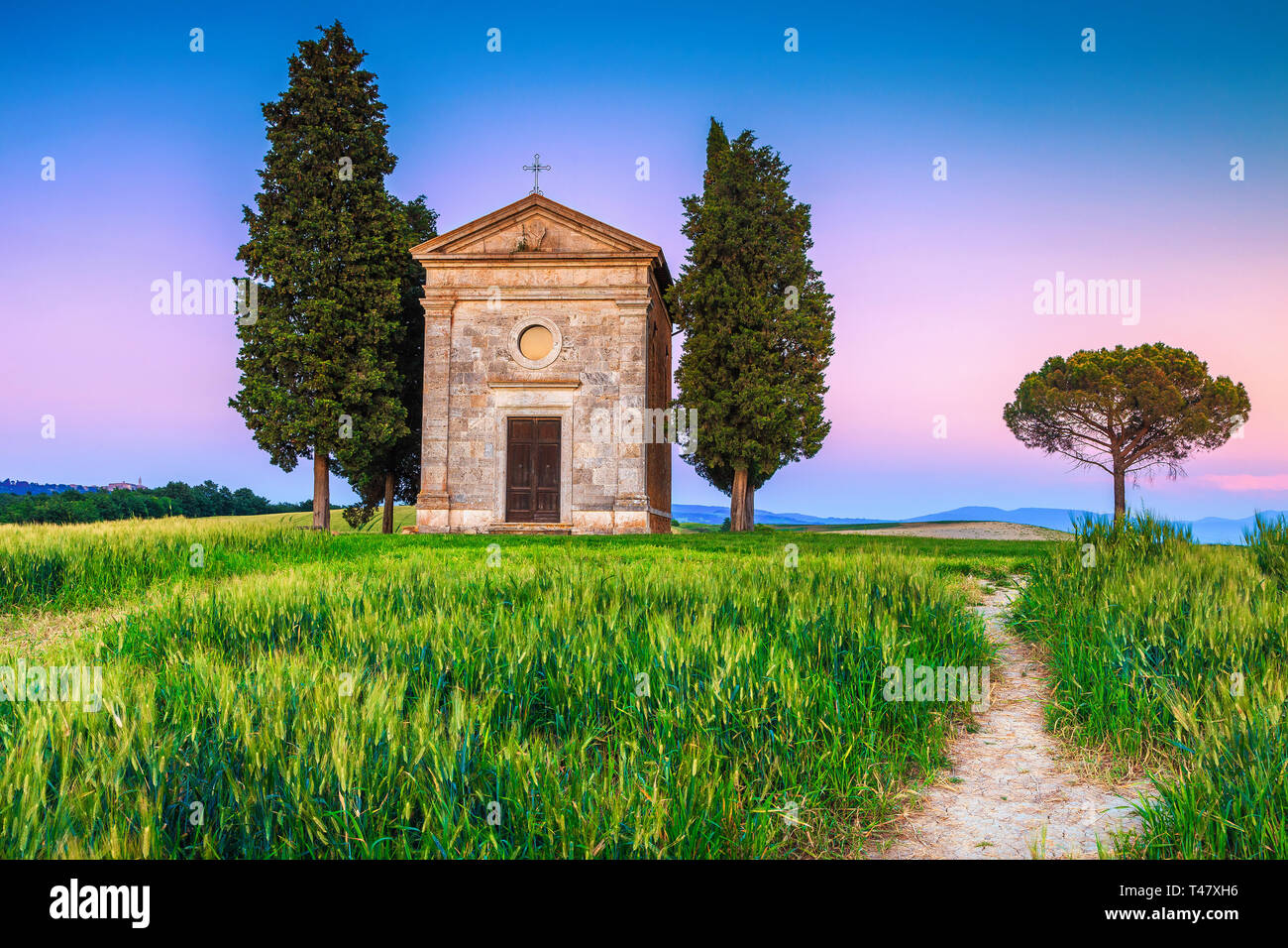 La photographie bien connue et touristique en Toscane, à l'étourdissement Vitaleta chapelle en champ de céréales d'été à soleil colorés, Pienza, Toscane, Italie, Euro Banque D'Images