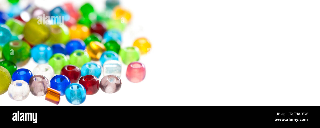 Gros plan sur les perles translucides colorées isolé sur fond blanc panoramique Banque D'Images