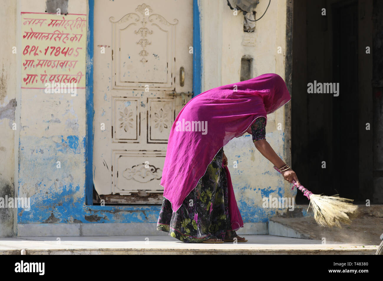 Indian woman sweeping the street i Rajasthan Banque D'Images