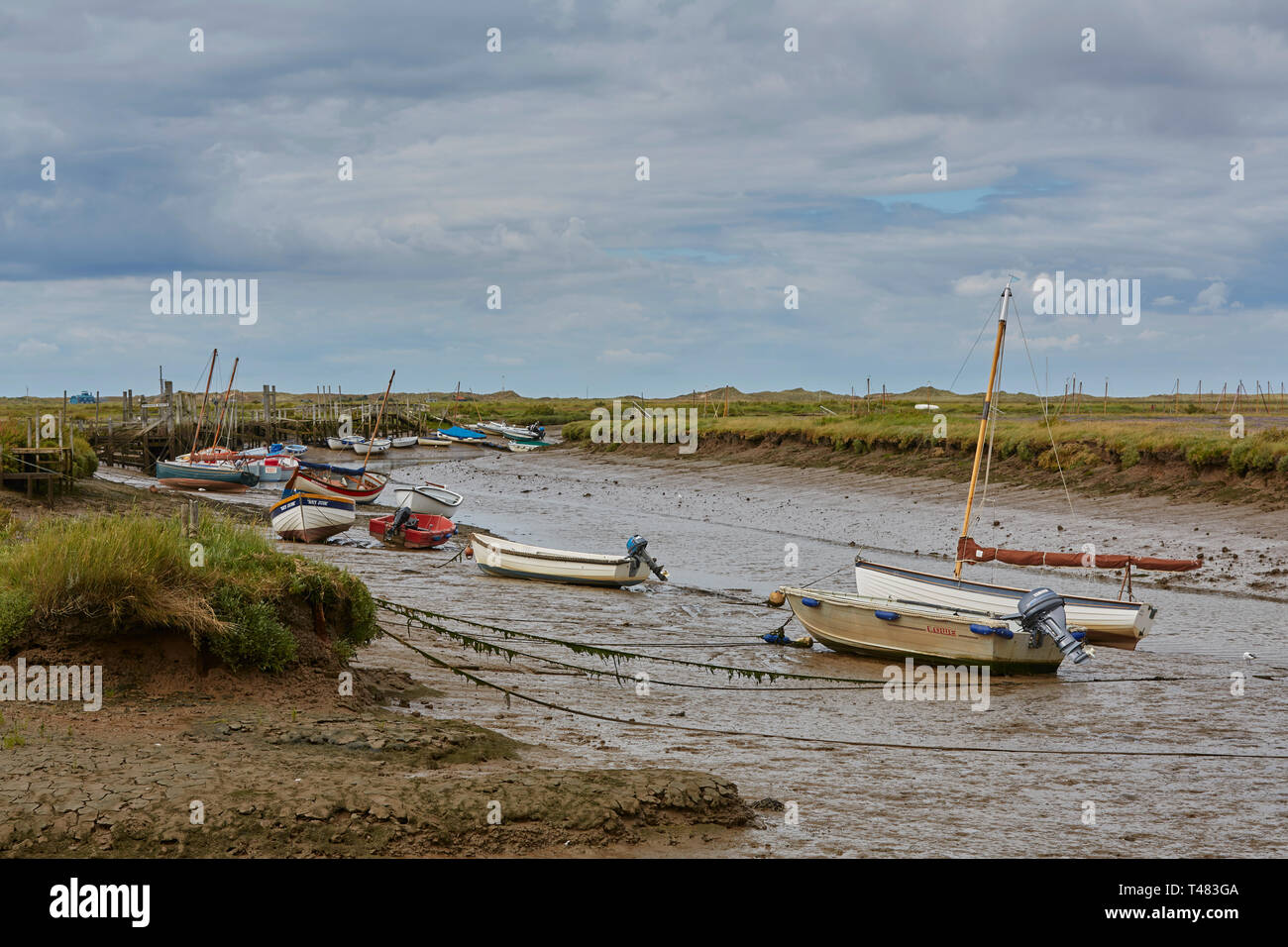 Un certain nombre de bateaux s'assit sur un lit de rivière boueuse après la marée est sorti sur un jour plus étés exprimés dans les Norfolk Broads, Norfolk, England, UK Banque D'Images