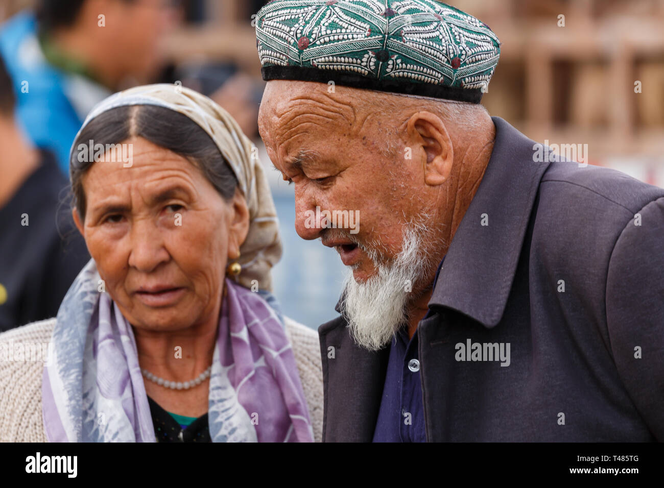 Portrait de personnes âgées Uyghur couple having a conversation à Kashgar Marché des animaux (Province du Xinjiang, Chine) Banque D'Images