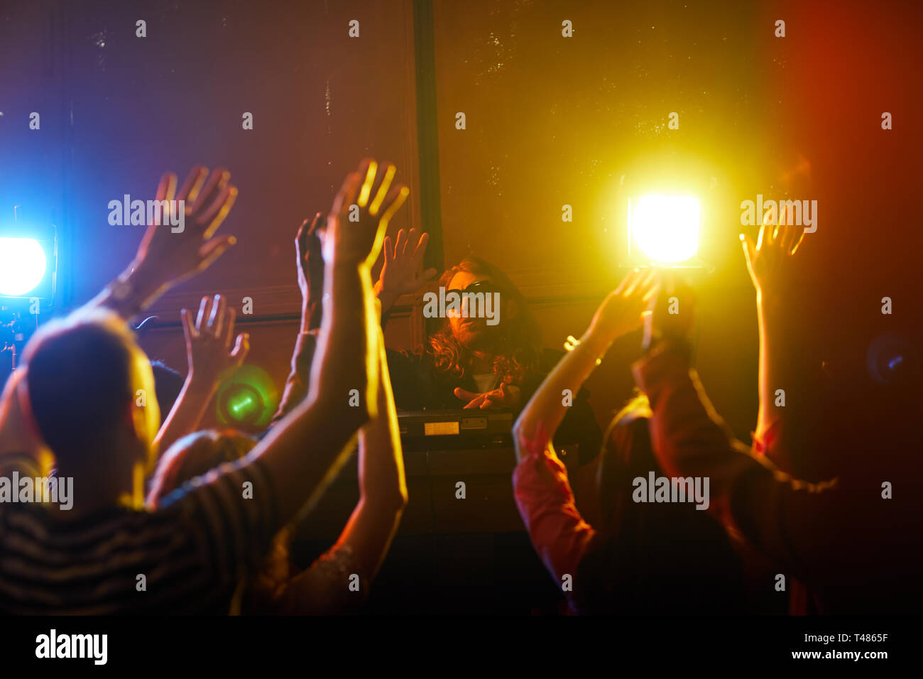 Jeune DJ en agitant les mains avec foule Banque D'Images