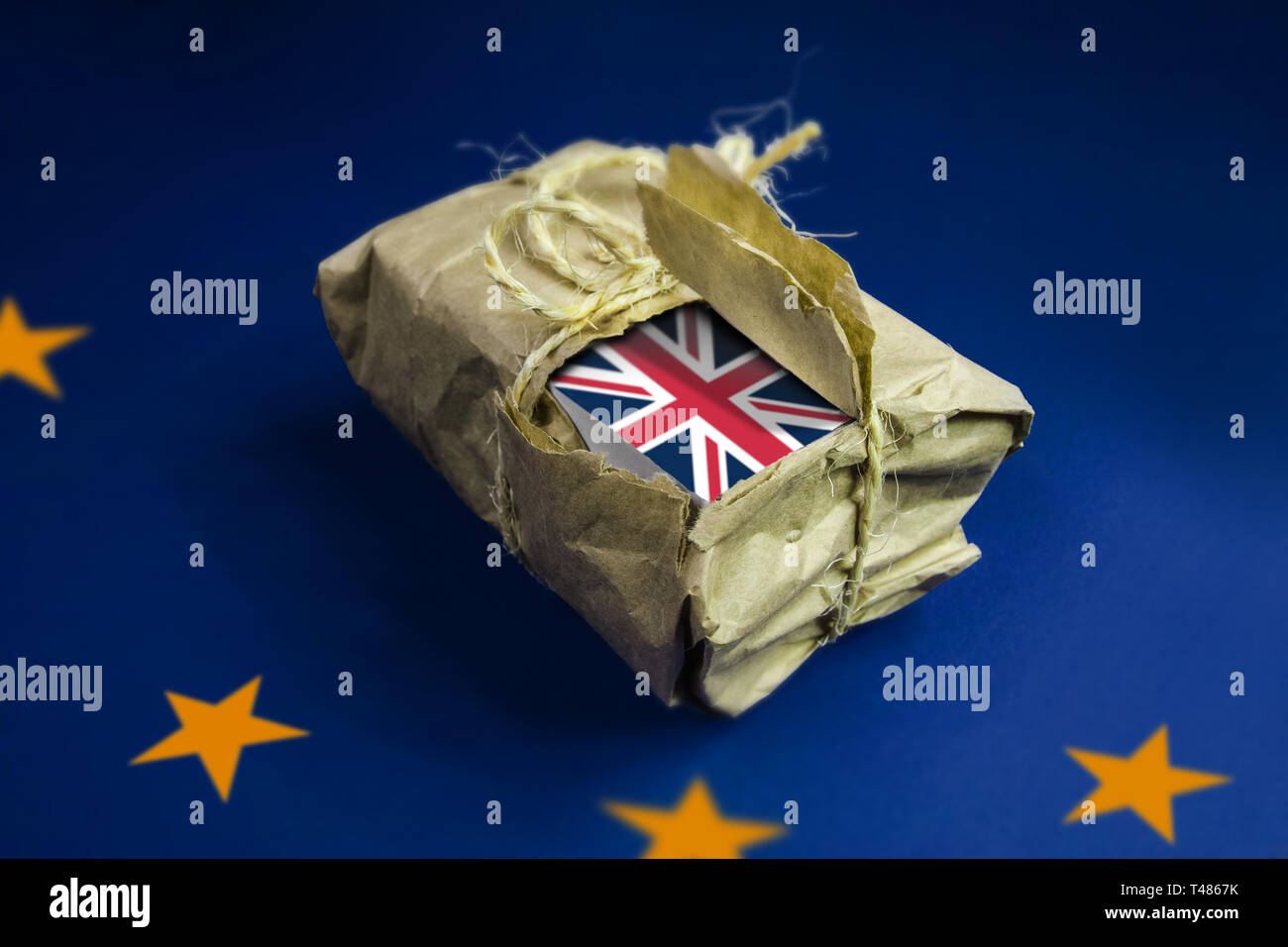 Sur le drapeau de l'UE, un post-pack enveloppé de papier brun. w et attaché avec une corde, est partiellement ouverte. Grâce à l'extraction de l'emballage, nous voyons le drapeau britannique. Banque D'Images