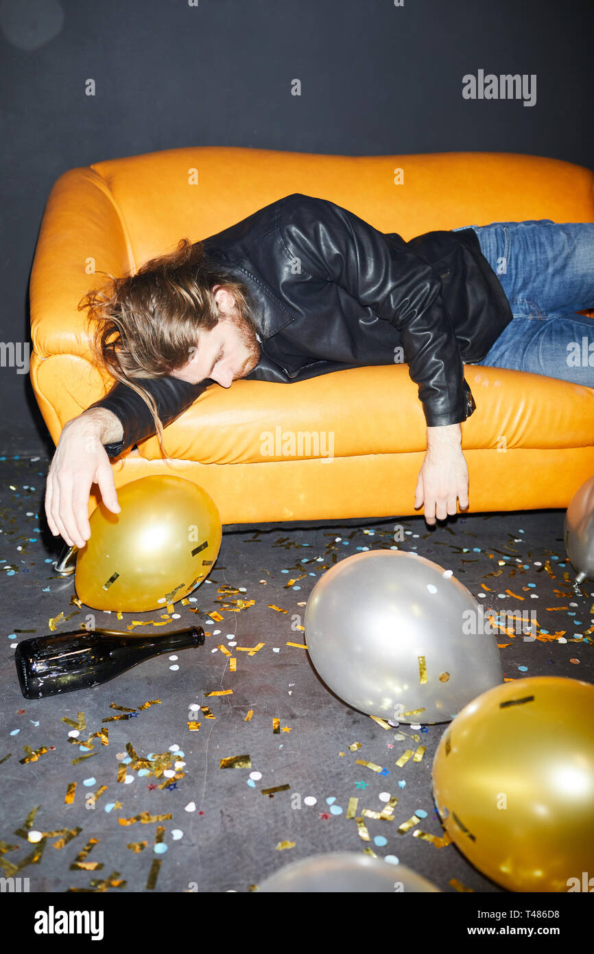 Drunk man sleeping on sofa in nightclub Banque D'Images