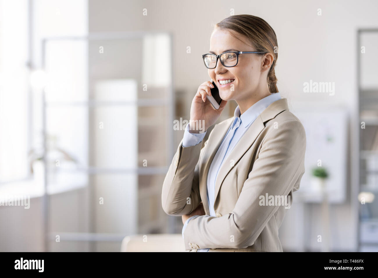 Happy young female manager parle au client sur le téléphone Banque D'Images