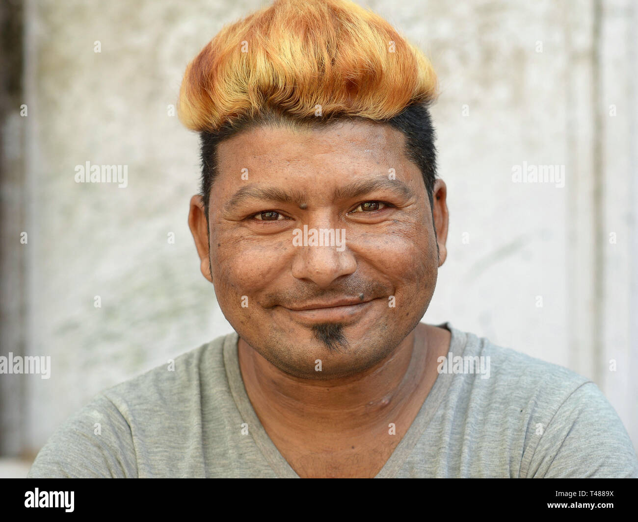 Jeune Indien homme Rajasthani avec golden-blonde cheveux teints et une âme patch fait courir à l'appareil photo. Banque D'Images