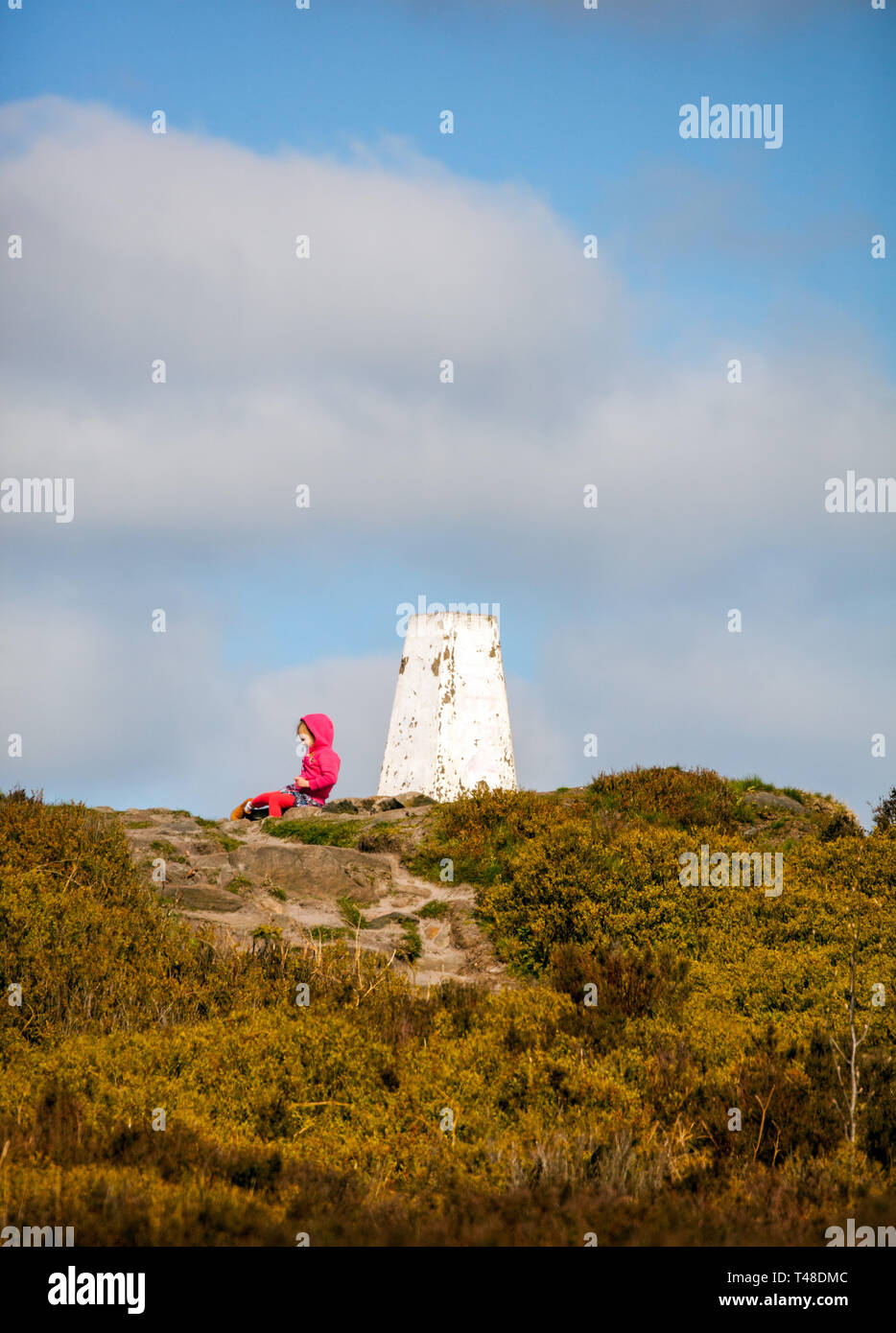 Jeune enfant à s'asseoir par l'Ordnance Survey trig point sur le dessus de la national trust Bosley / Cloud Cloud fin près de Congleton Cheshire England UK Banque D'Images