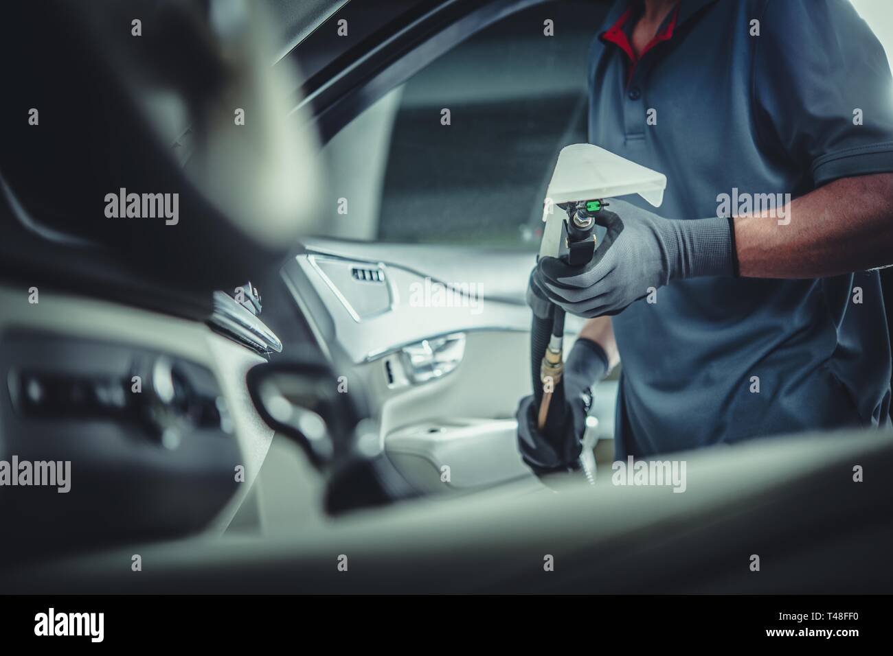 Service de nettoyage pour les professionnels. Caucasian Worker with Wet Aspirateur à sec en mains la préparation de tissus intérieurs lave. Banque D'Images