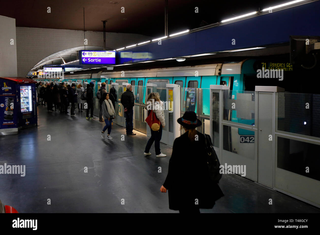 Les gens sur la plate-forme de Paris Métro ligne 13 station "Invalides" l'un de plusieurs stations équipées de portes palières, Paris, France Banque D'Images