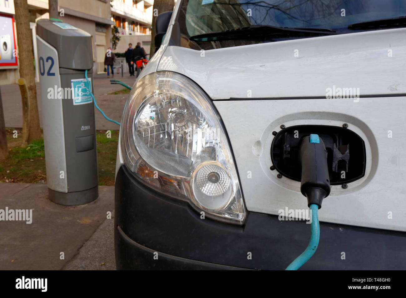 Une voiture électrique se recharge dans une station de charge à côté du trottoir à Paris, en France Banque D'Images