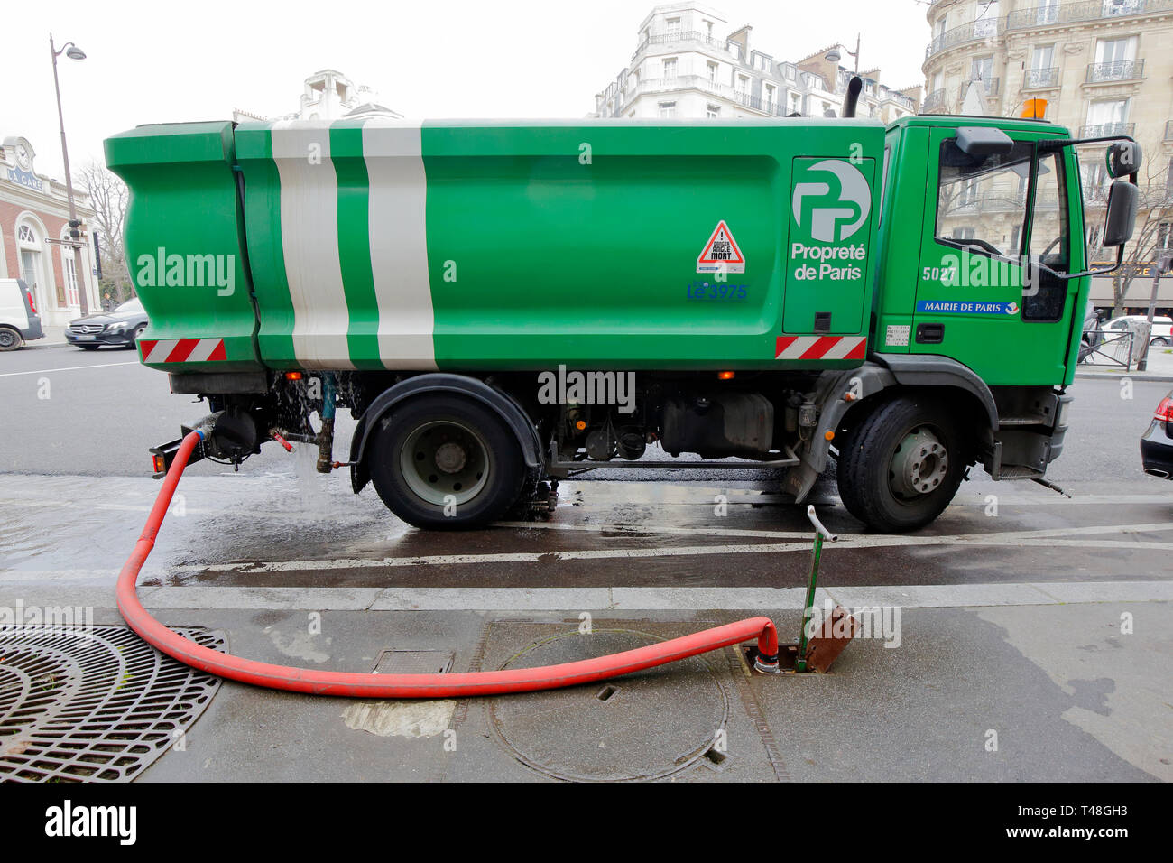 Un camion d'eau sanitaire de Paris propreté se remplit d'une bouche d'incendie au sol, Paris, France Banque D'Images