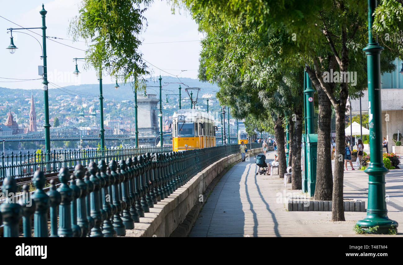 Ancien Tramway jaune Gantz à Budapest en marche à côté du Danube avec le Pont des chaînes Széchenyi dans la distance . Banque D'Images