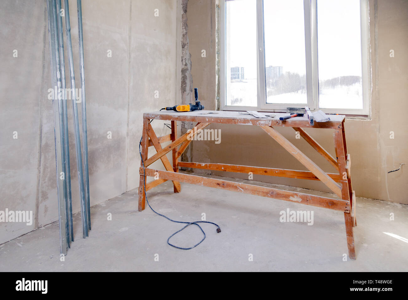 les-chafaudages-en-bois-stand-la-fen-tre-dans-une-grande-salle-vide