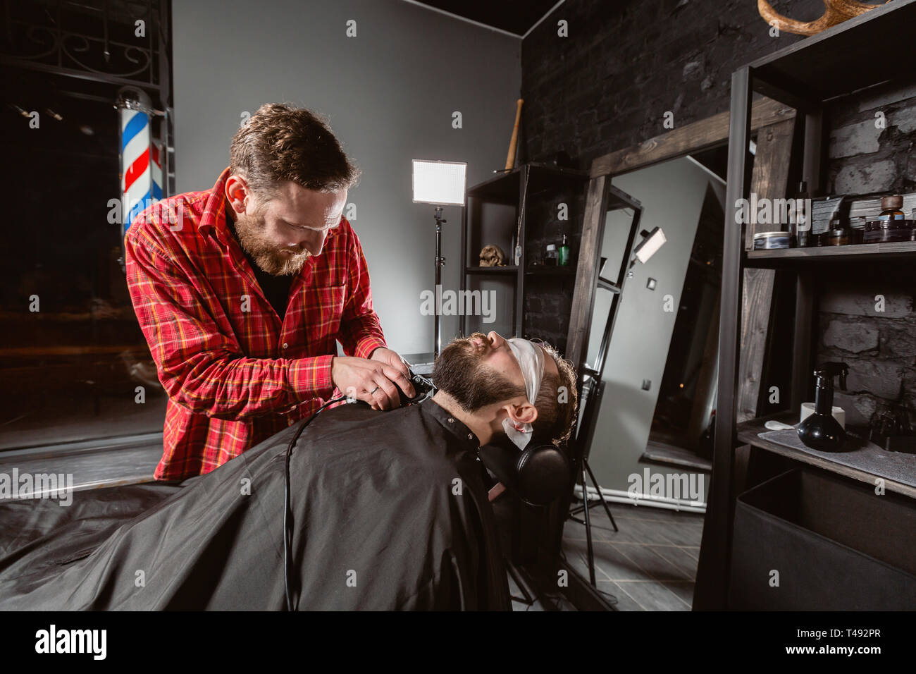 Coupe de la barbe, le soin du visage. Coiffure travailler avec machine à  clipper dans ce type. Tondeuse professionnelle cheveux et barbe coupe de  l'outil de jeunes gars dans barber shop Photo