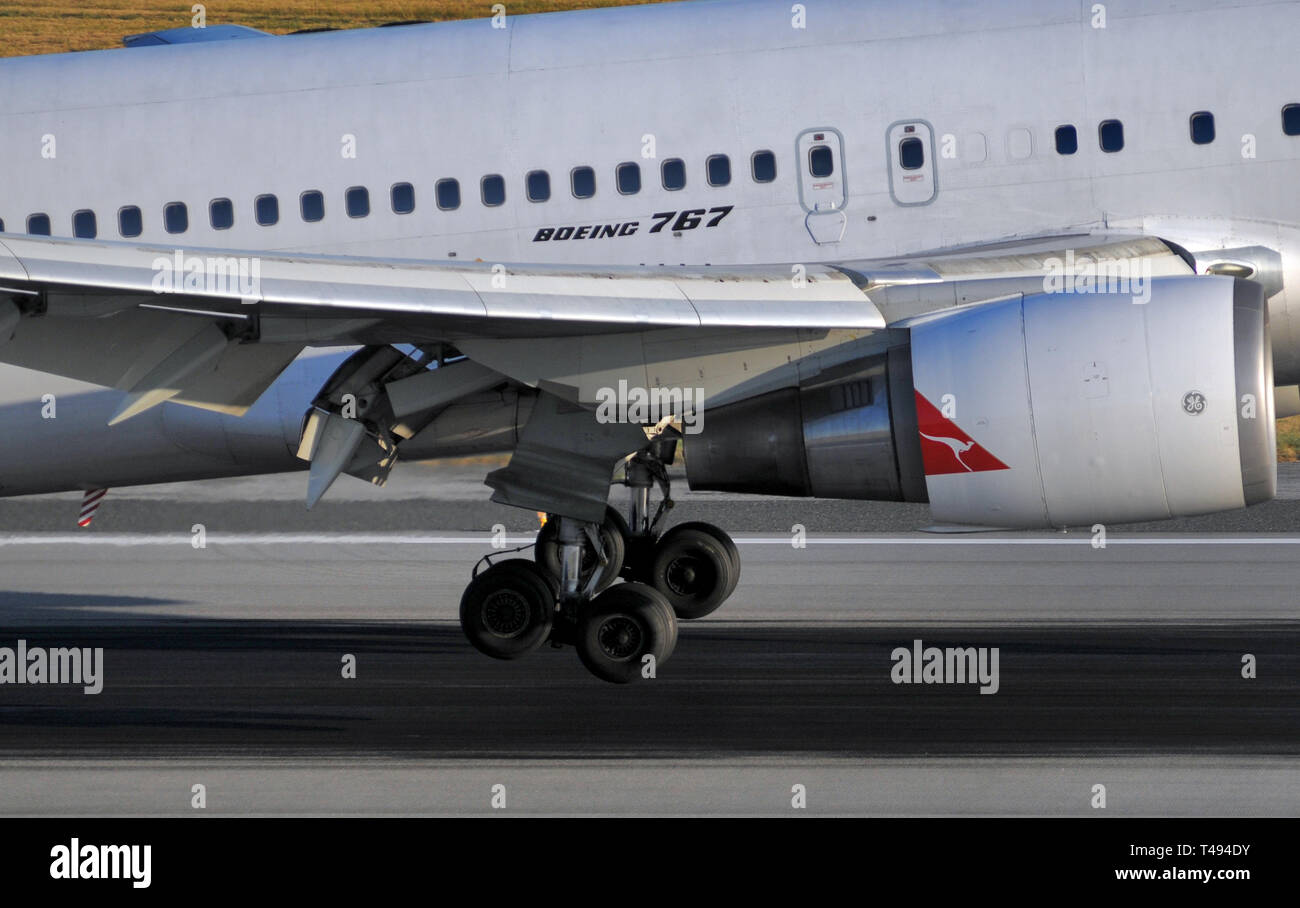 Vue rapprochée de l'atterrissage principal et moteur d'un avion Boeing 767 de Qantas à l'atterrissage. Banque D'Images