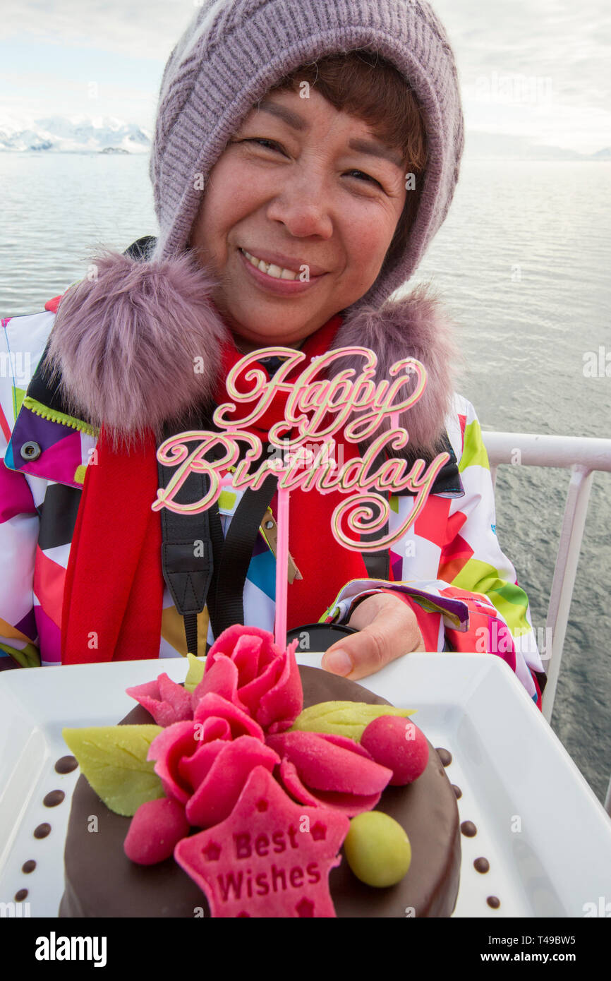 Un Touriste Chinois Etant Presente Avec Un Gateau D Anniversaire Sur Un Bateau De Croisiere Antarctique Au Large De La Peninsule Antarctique Photo Stock Alamy