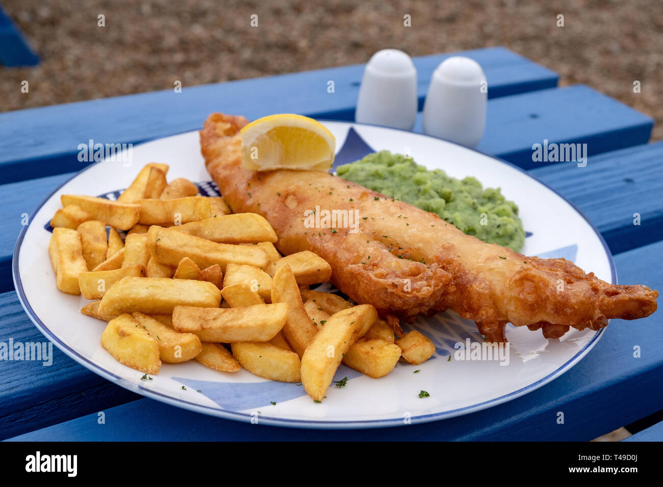 Fish and chips traditionnel servi avec une portion de petits pois. Banque D'Images