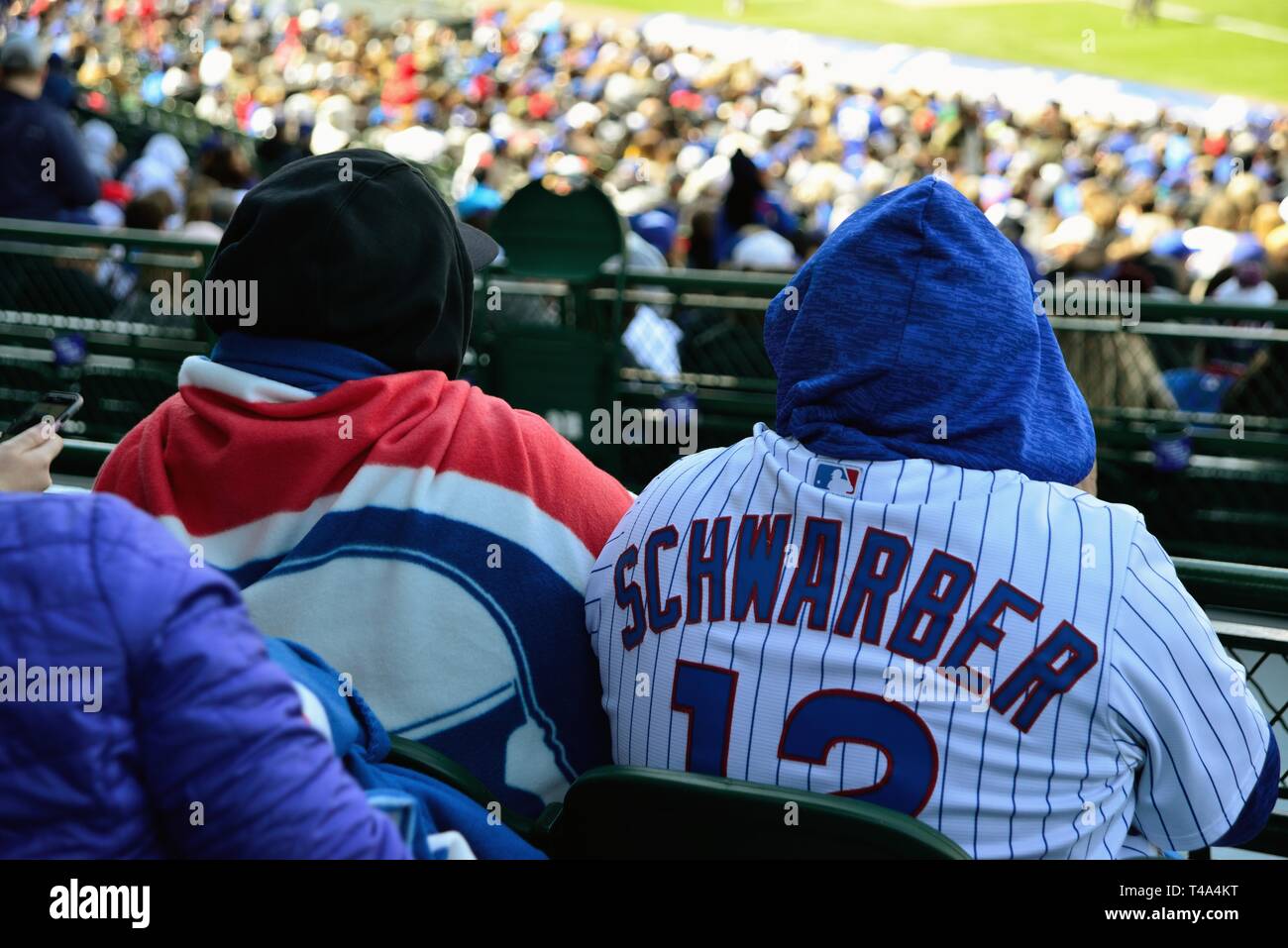 Chicago, Illinois, USA. Emmitouflés dans les sièges des fans un match à Wrigley Field, stade des Chicago Cubs. Banque D'Images