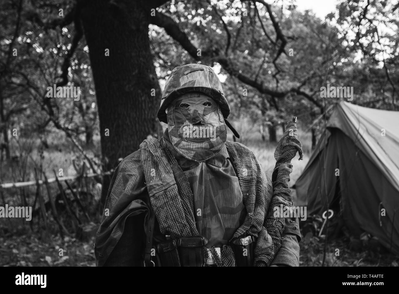 La reconstitution médiévale caché habillé comme la Seconde Guerre mondiale, Soldat Wehrmacht Sniper en forêt. Fermer Portrait en camouflage. Photo en noir et blanc. Banque D'Images