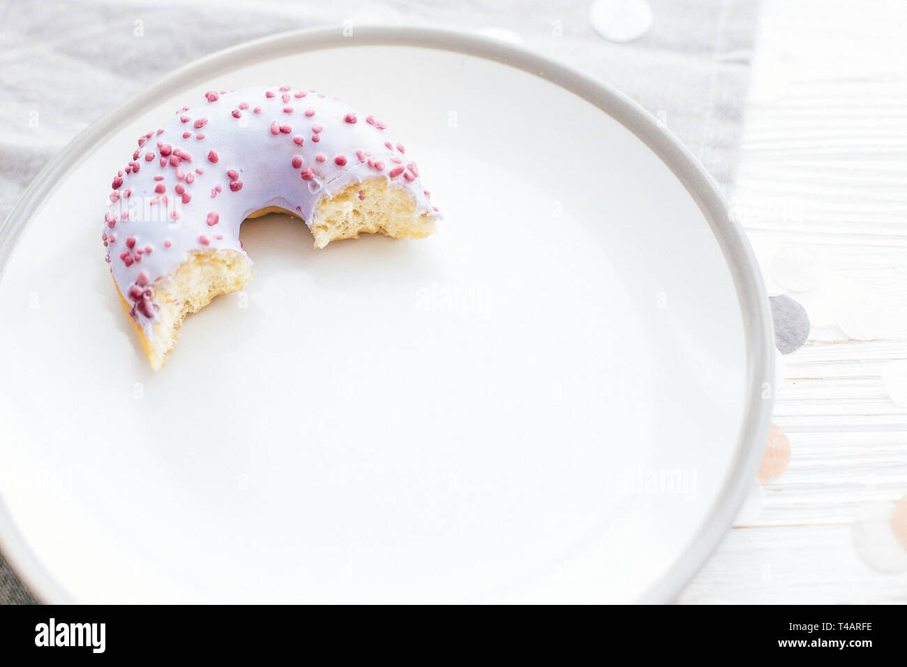 Délicieux plats de donut avec sprinkles sur plaque élégant avec cuillère sur tableau blanc de confettis. Partie concept. Pas de régime alimentaire. Bar à bonbons/mariage Banque D'Images