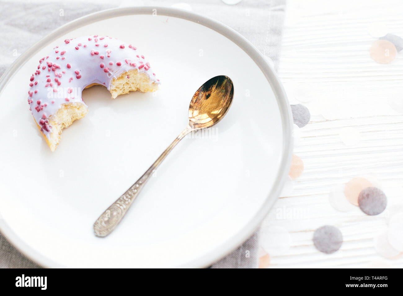 Délicieux plats de donut avec sprinkles sur plaque élégant avec cuillère sur tableau blanc de confettis. Partie concept. Pas de régime alimentaire. Bar à bonbons/mariage Banque D'Images