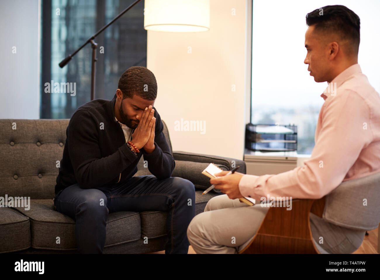 Malheureux homme assis sur la table Rencontre avec homme Conseiller dans Office Banque D'Images