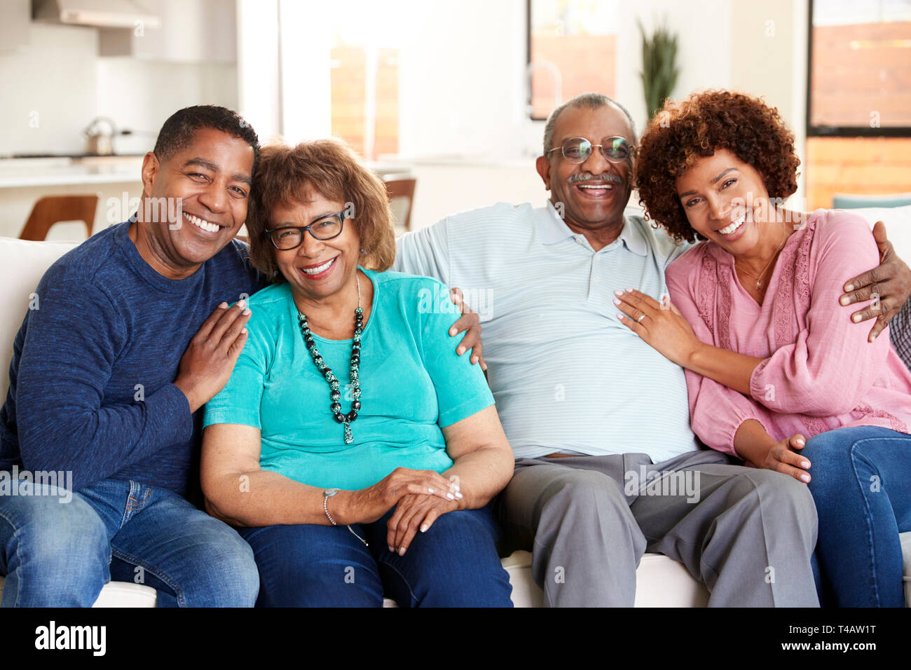 Black couple d'âge moyen et les parents assis à la maison, souriant à l'appareil photo Banque D'Images