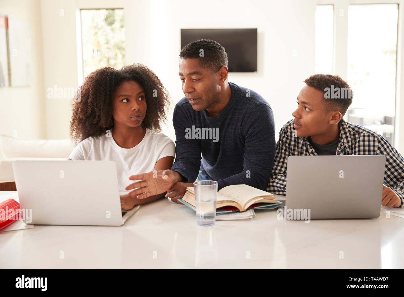 Noir d'âge moyen d'aider son père enfants adolescents à faire leurs devoirs, vue de face, Close up Banque D'Images