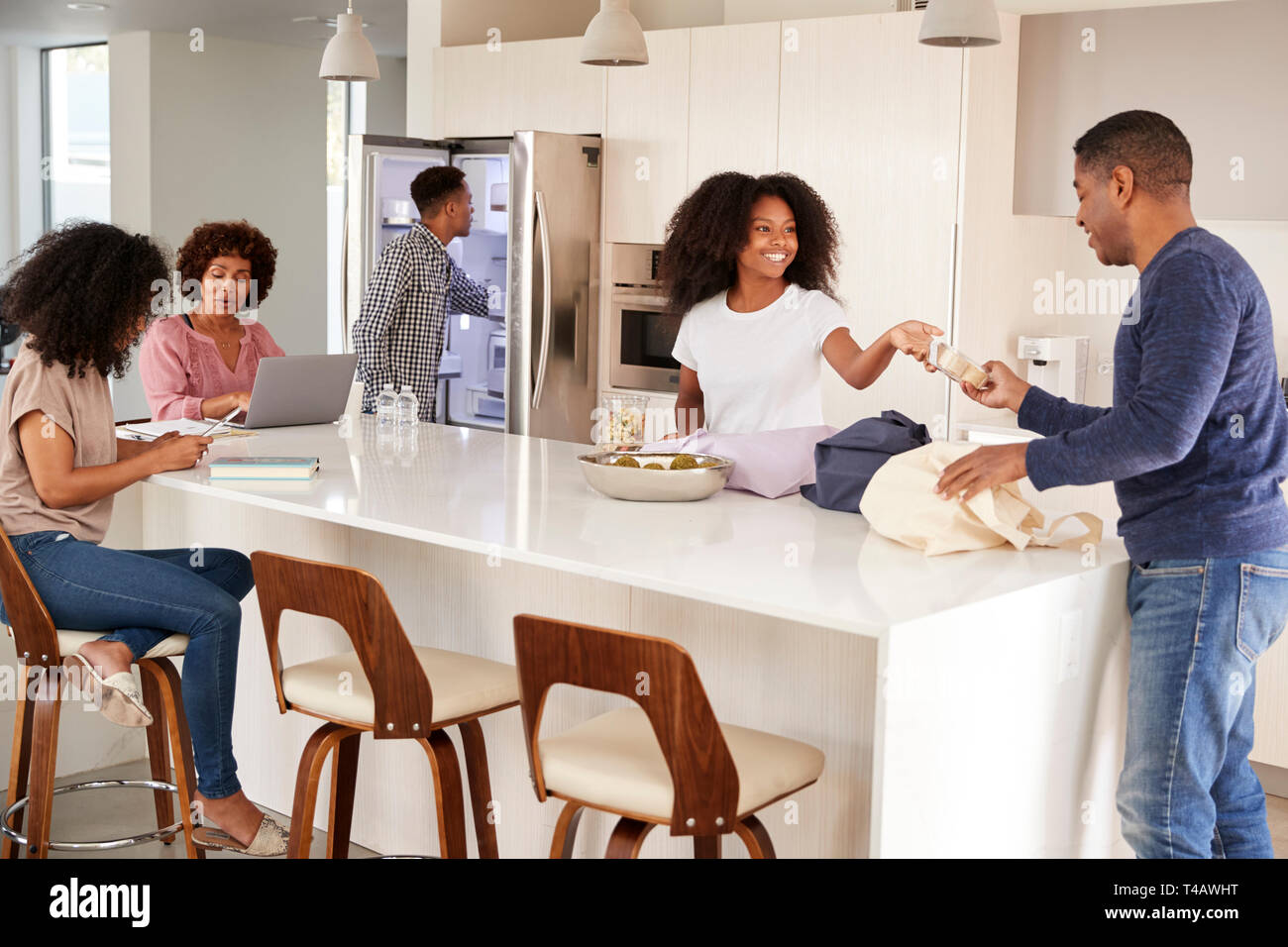 La famille noire de déballer l'épicerie et passer du temps dans leur ensemble de cuisine Banque D'Images