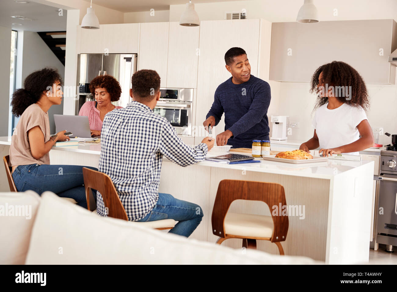 Happy black famille à leur cuisine île, parler et de préparer vos repas en famille Banque D'Images