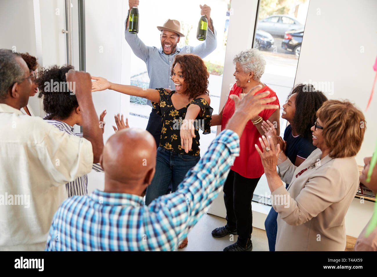 Millennial black couple arrivant à une fête familiale avec des cadeaux et champagne, elevated view Banque D'Images