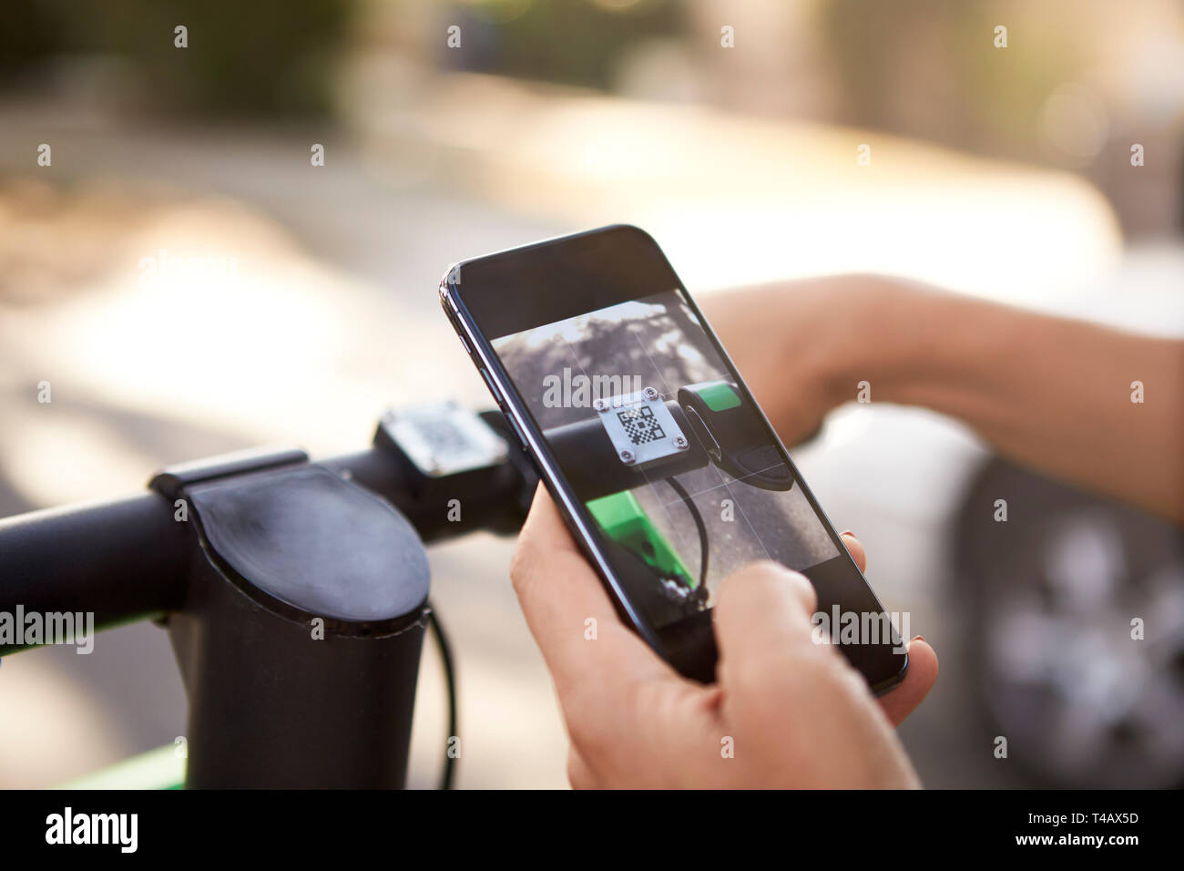 Close up of woman's hands using smartphone tout en montant sur un scooter électrique,détail Banque D'Images
