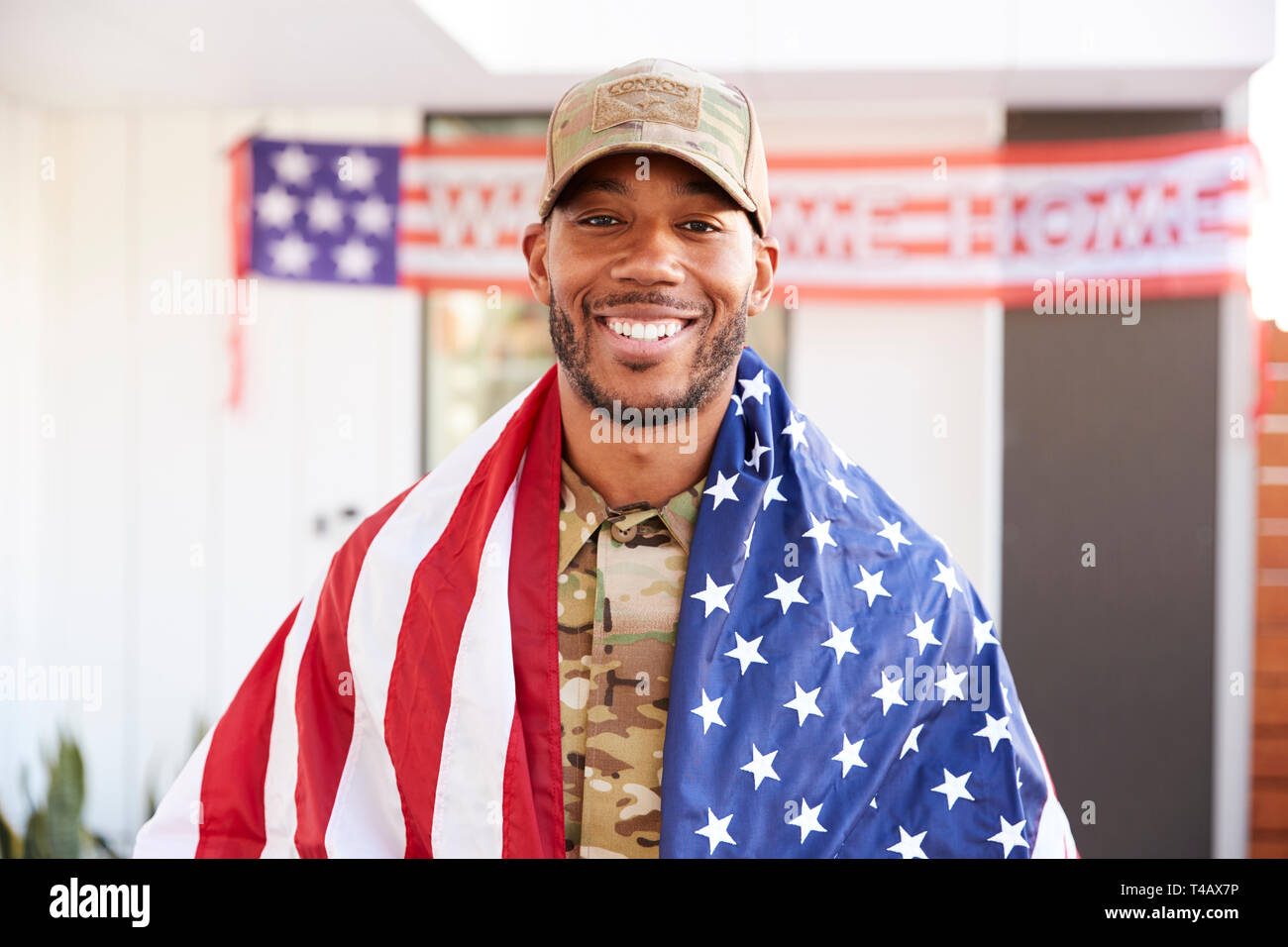 Soldat noir millénaire avec nous d'un drapeau drapé sur ses épaules, souriant à la caméra, Close up Banque D'Images