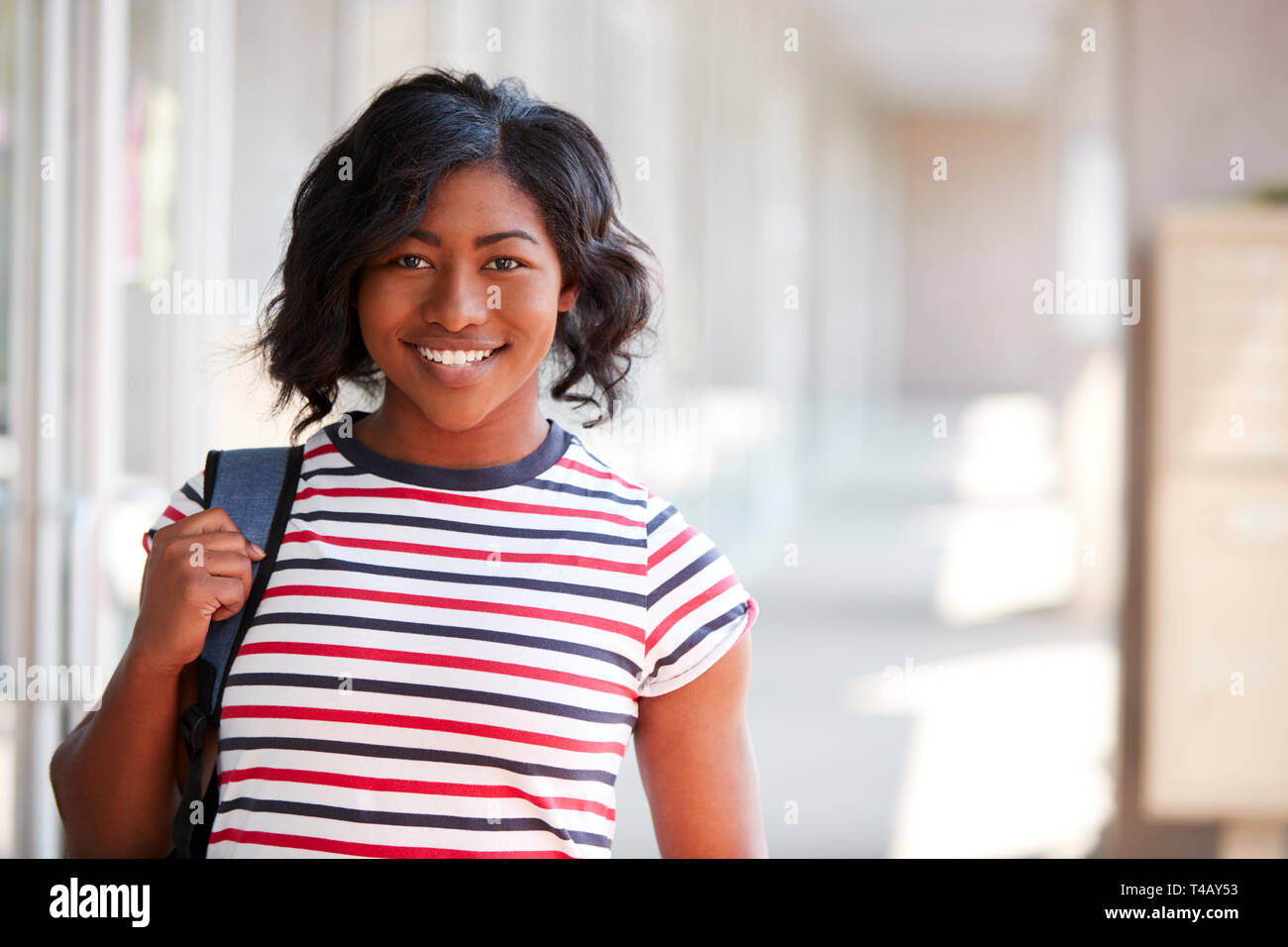 Portrait Of Smiling Female University Student avec sac à dos dans le couloir du bâtiment du collège Banque D'Images