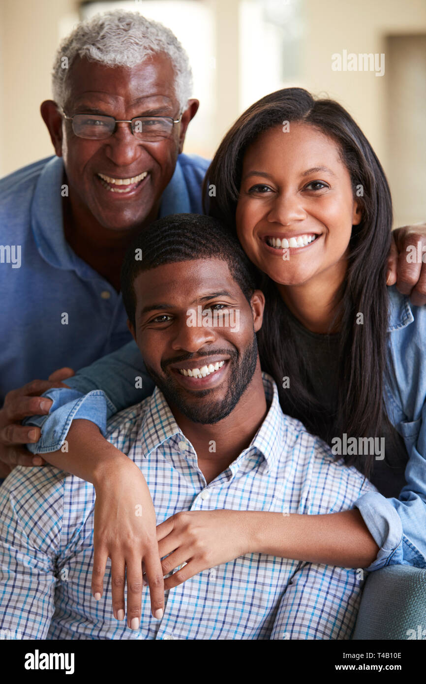 Portrait Of Smiling Senior père avec son fils et sa fille adultes Hugging At Home Banque D'Images
