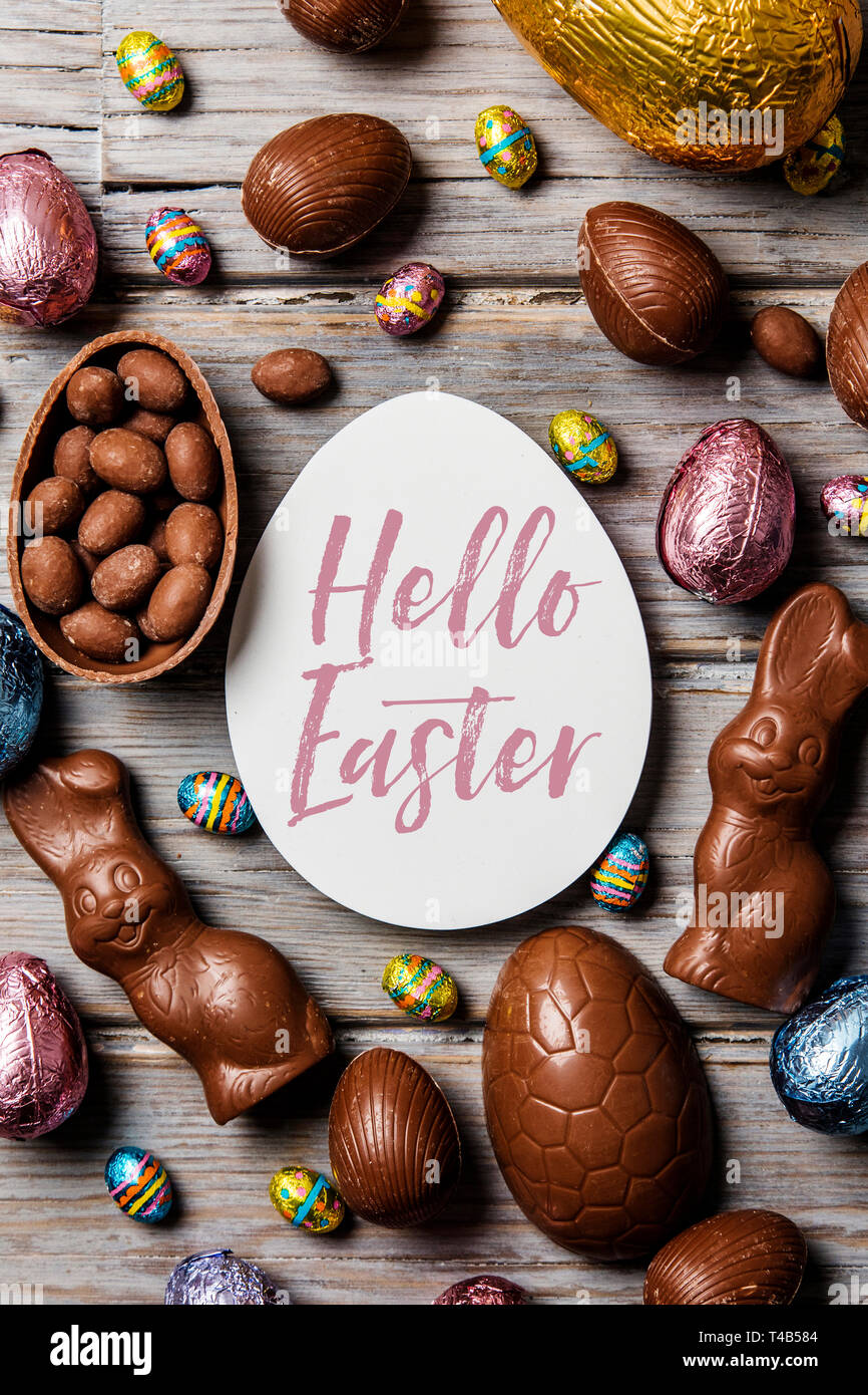 Les oeufs de pâques en chocolat et les lapins sur un fond de bois rustique Banque D'Images