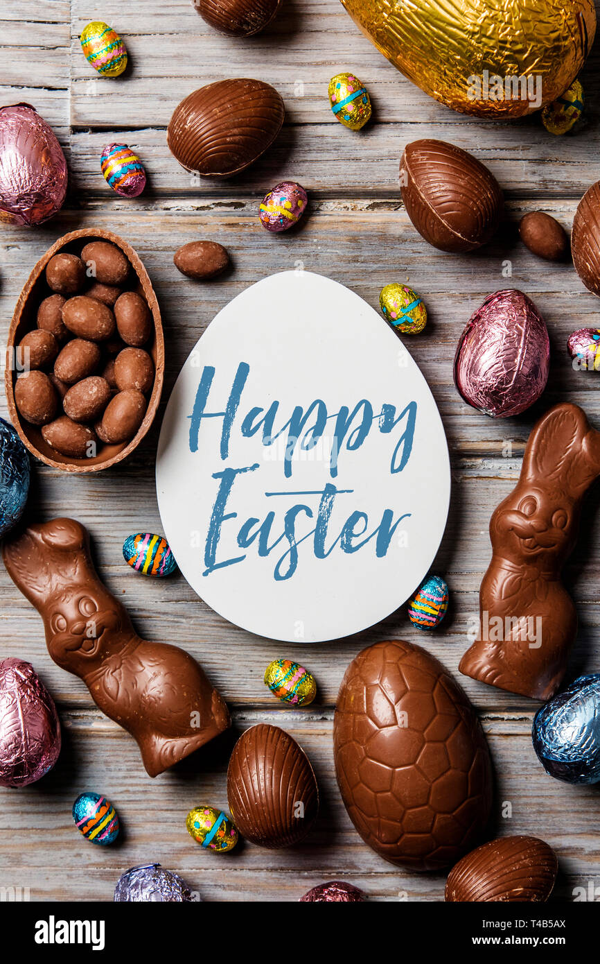 Les oeufs de pâques en chocolat et les lapins sur un fond de bois rustique Banque D'Images