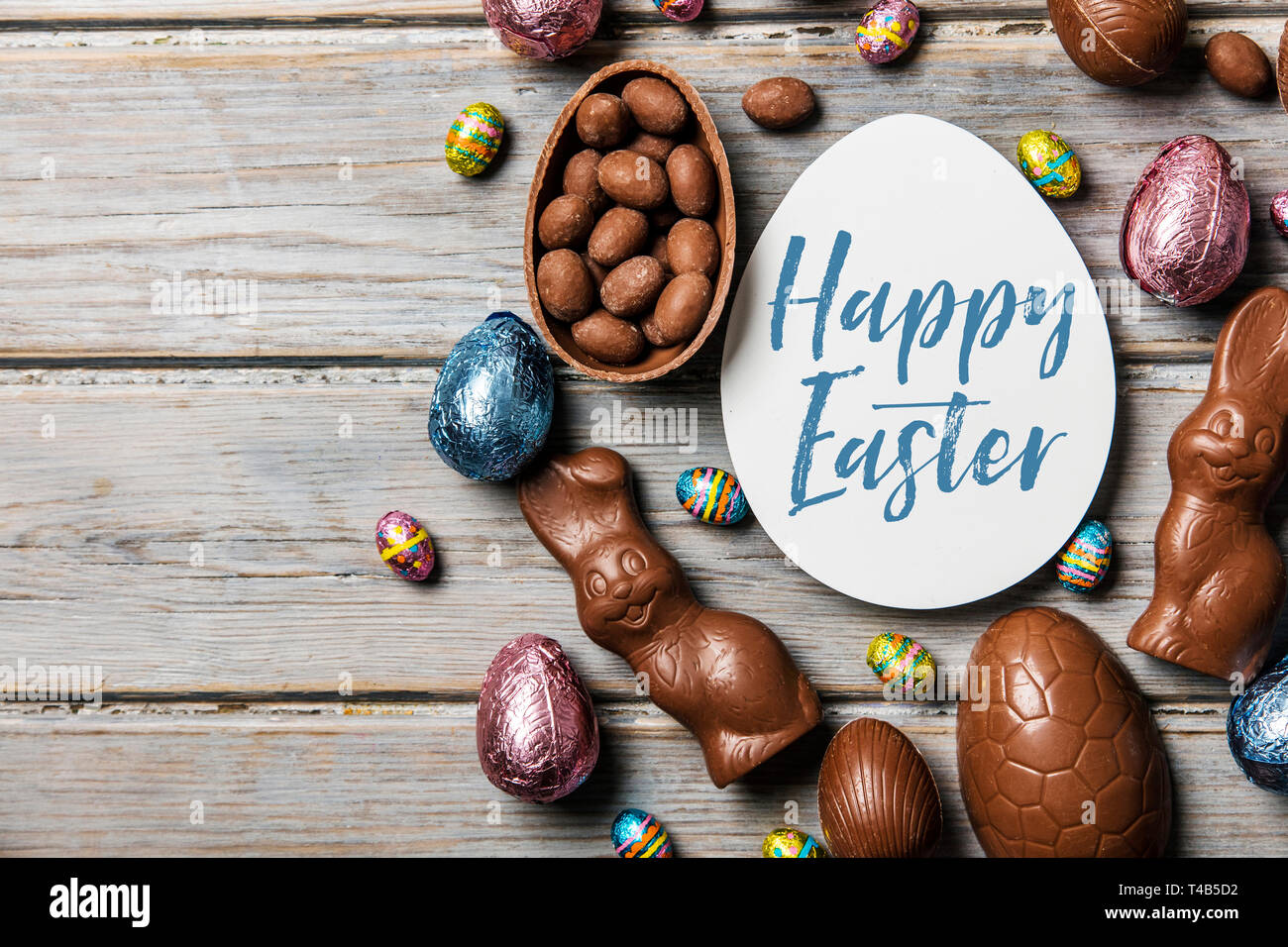 Les oeufs de pâques en chocolat et les lapins sur un fond de bois rustique Banque D'Images
